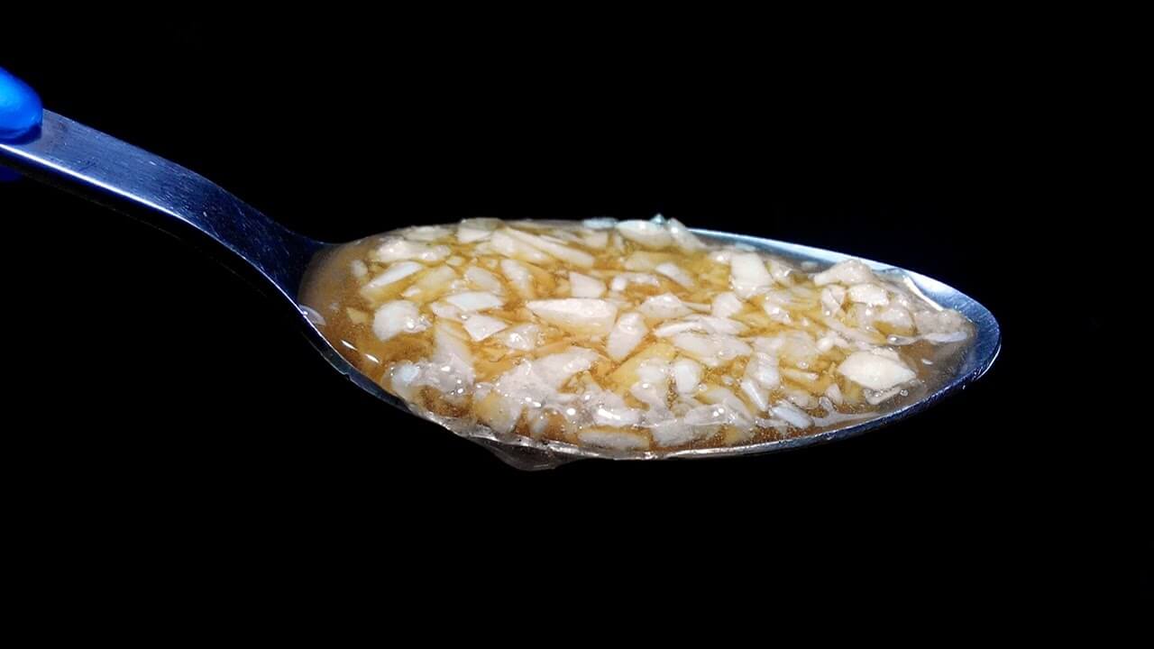Crushed or Chopped Garlic in Honey on a Spoon