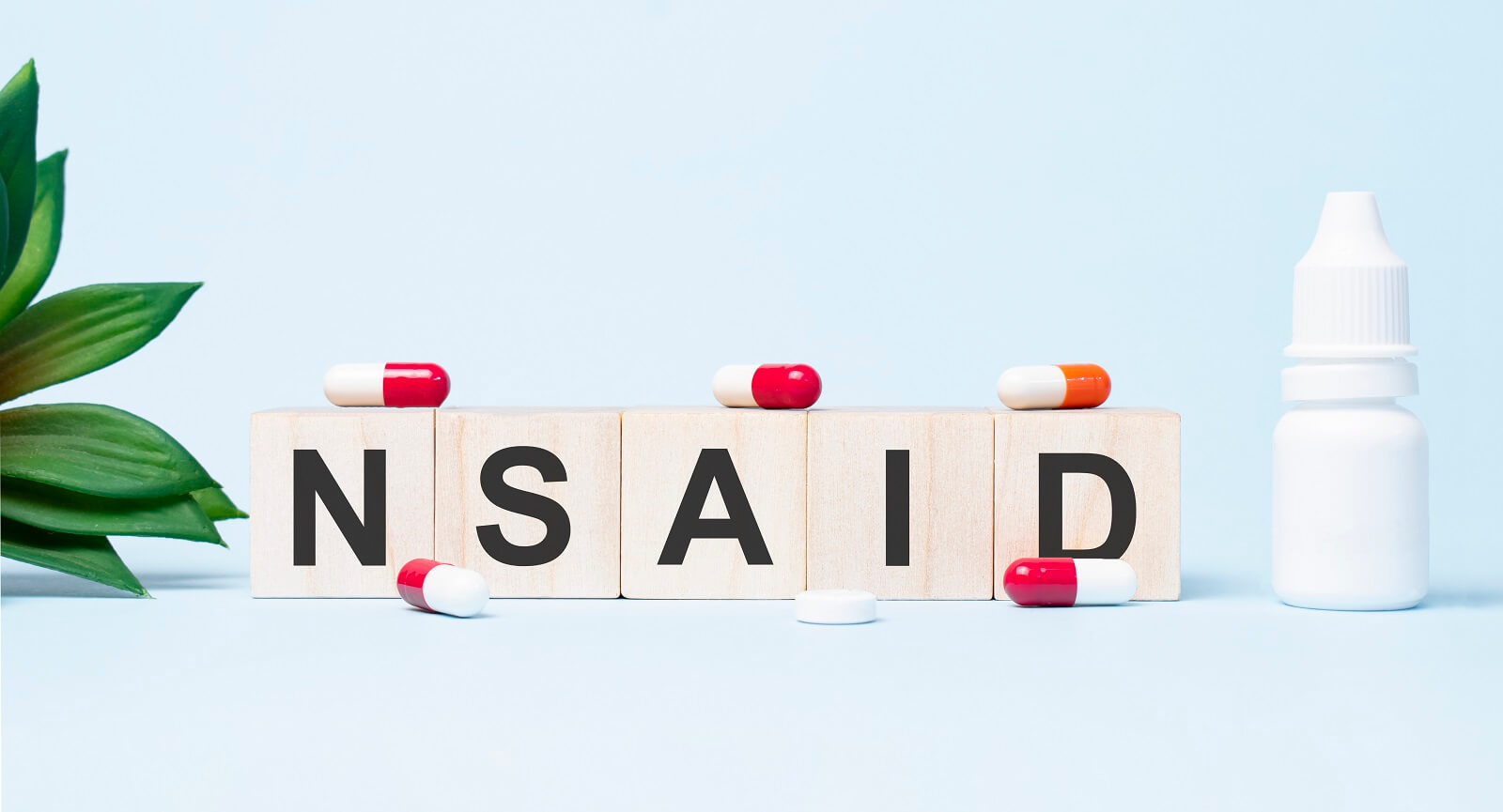 Nsaid word made with building blocks. A row of wooden cubes with a word written in black font is located on white background.