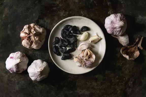 varieties of garlic. Black garlic and regular garlic on a plate.
